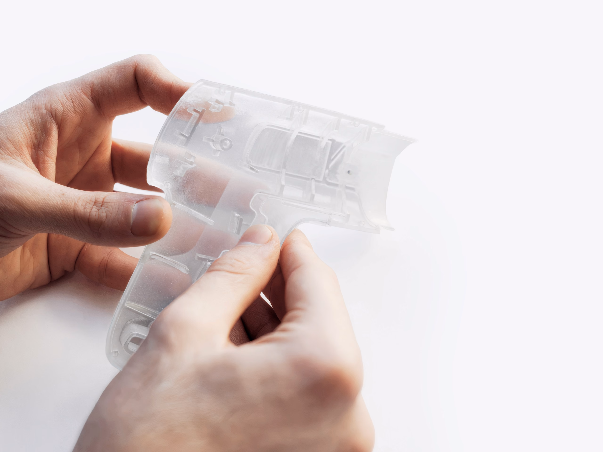 Hands examining 3D printed transparent prototype shell of Pro Mini